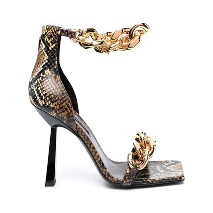 High-heeled shoe with snake print and gold chain on a white background