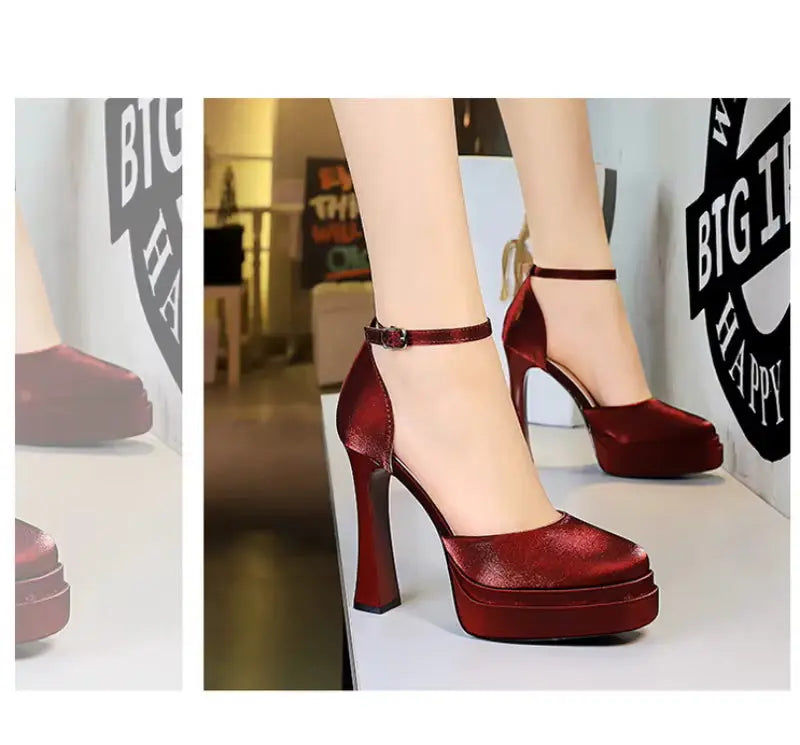 Red high-heeled shoes worn by a person with a blurred indoor background