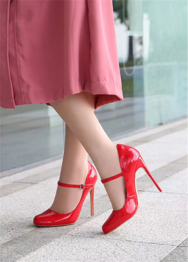 Red high-heeled shoes worn with a pink skirt on a light background